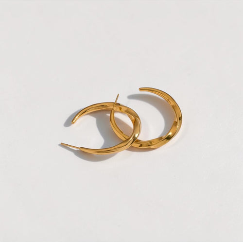 Gold hoop earrings on a light gray background