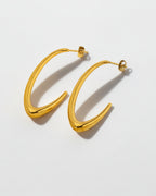Gold hoop earrings on a light gray background