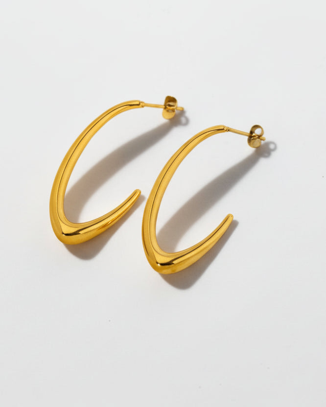 Gold hoop earrings on a light gray background