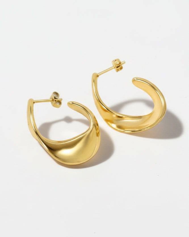Pair of gold hoop earrings on a light gray background