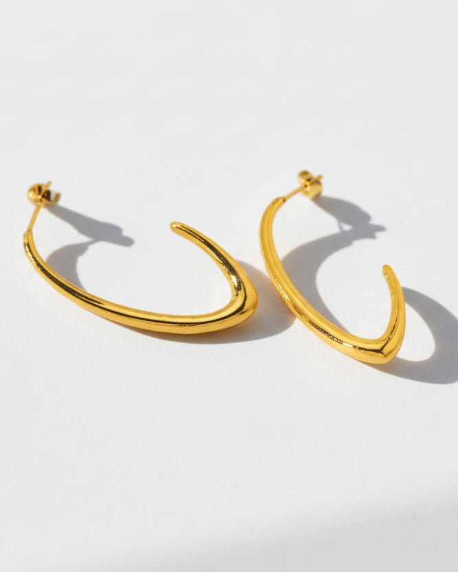 Gold hoop earrings on a light gray background