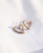 Gold heart-shaped earrings on a white background