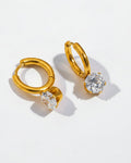 Gold hoop earrings with clear gemstones on a light gray background