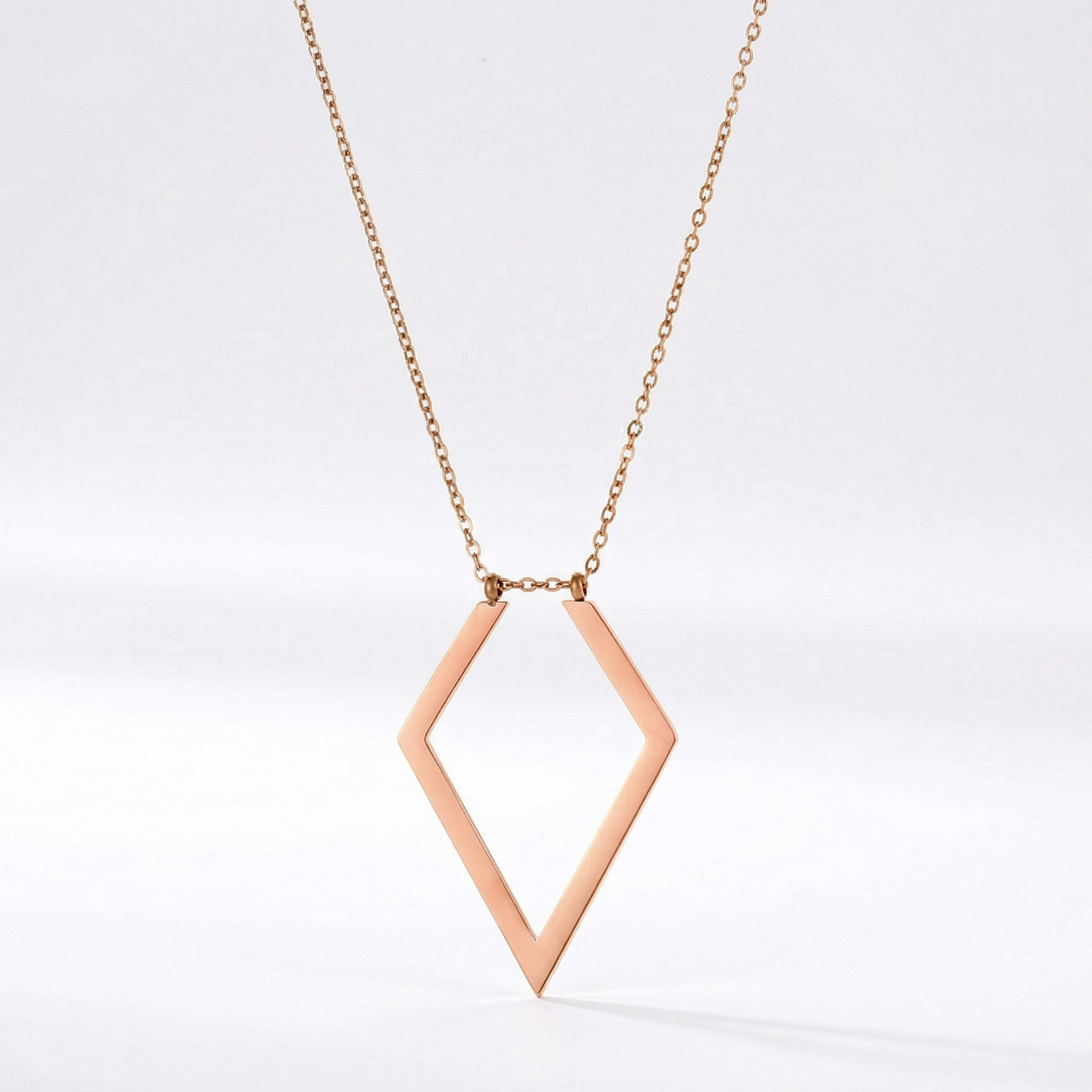 Rose gold diamond-shaped necklace on a white background