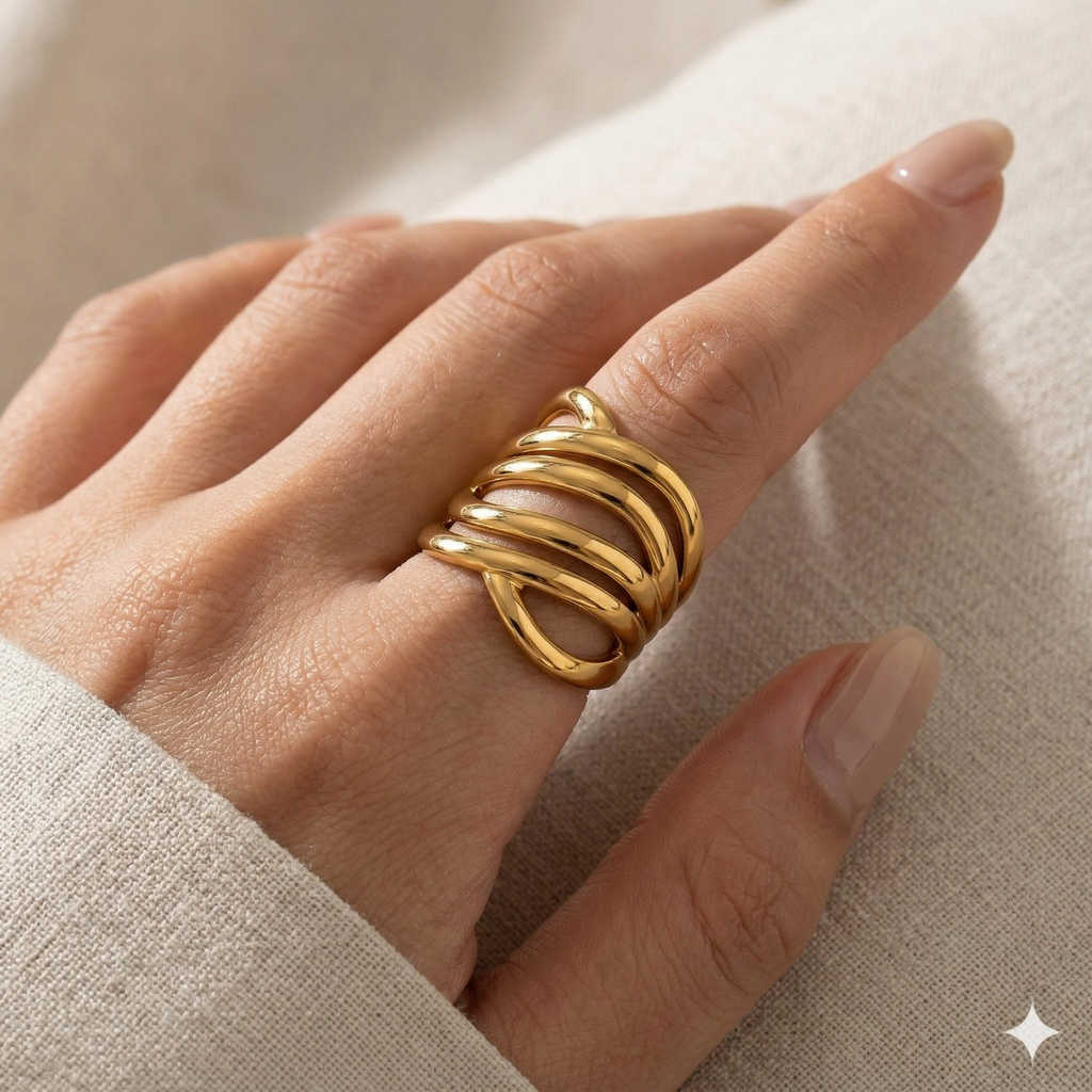 Gold ring on a hand against a neutral background