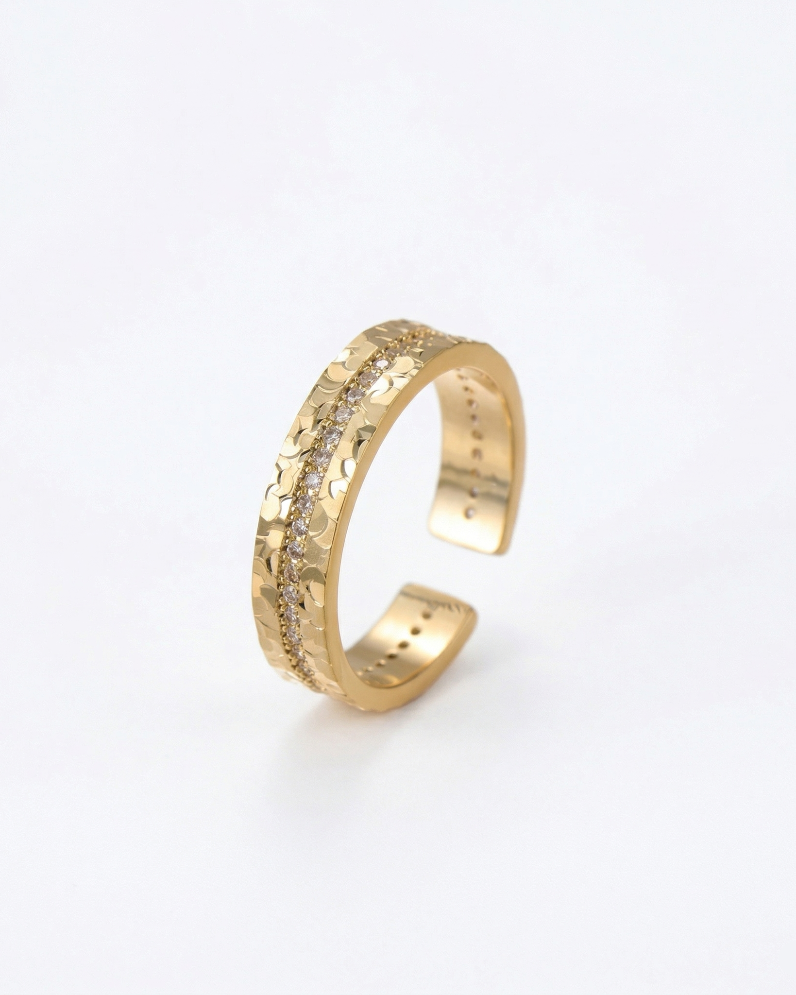 Gold open ring with textured design on a white background