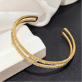 Gold bracelet with embedded stones on a black surface